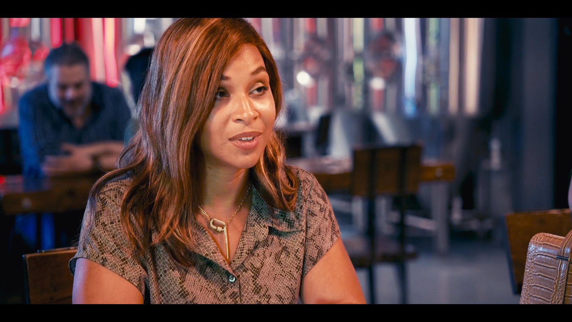 A customer engages in a conversation with a waiter behind a service counter at a restaurant. The discussion focuses on menu selection and service details within a casual dining environment.