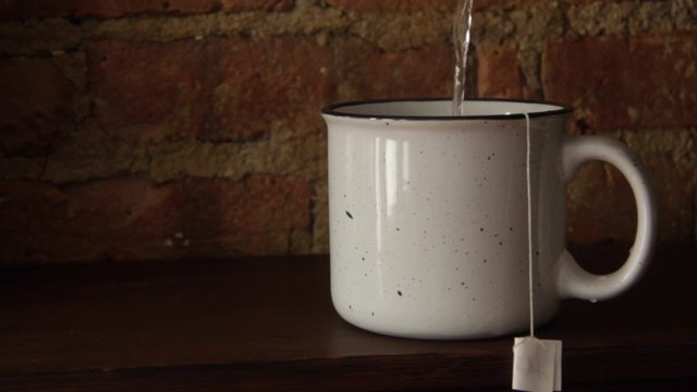 Hot water being poured into a cup of tea