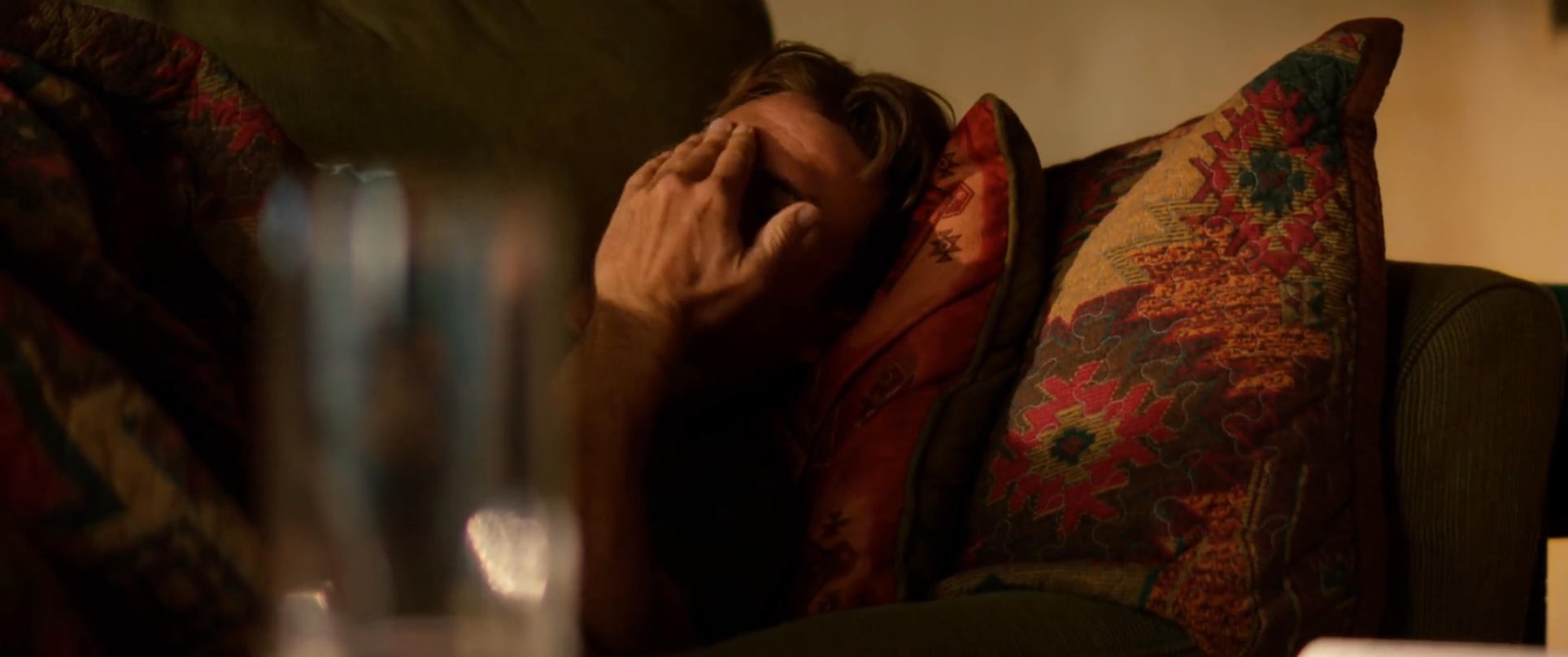 A person prepares coffee in a kitchen before transitioning to a living room where they slowly wake up and stretch on a couch. The scene captures a quiet, leisurely start to the morning in a comfortable domestic setting.