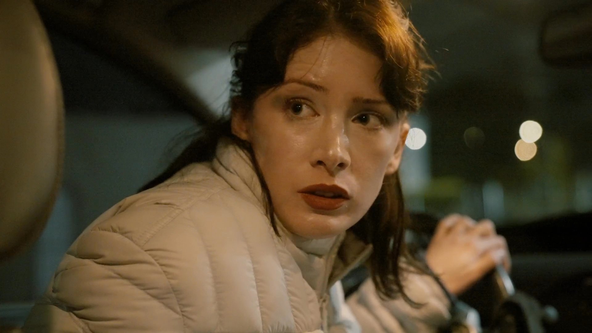 Three individuals engage in a tense conversation while traveling in a vehicle through an urban environment at night. The dialogue and expressions reflect a moment of significant interpersonal conflict.
