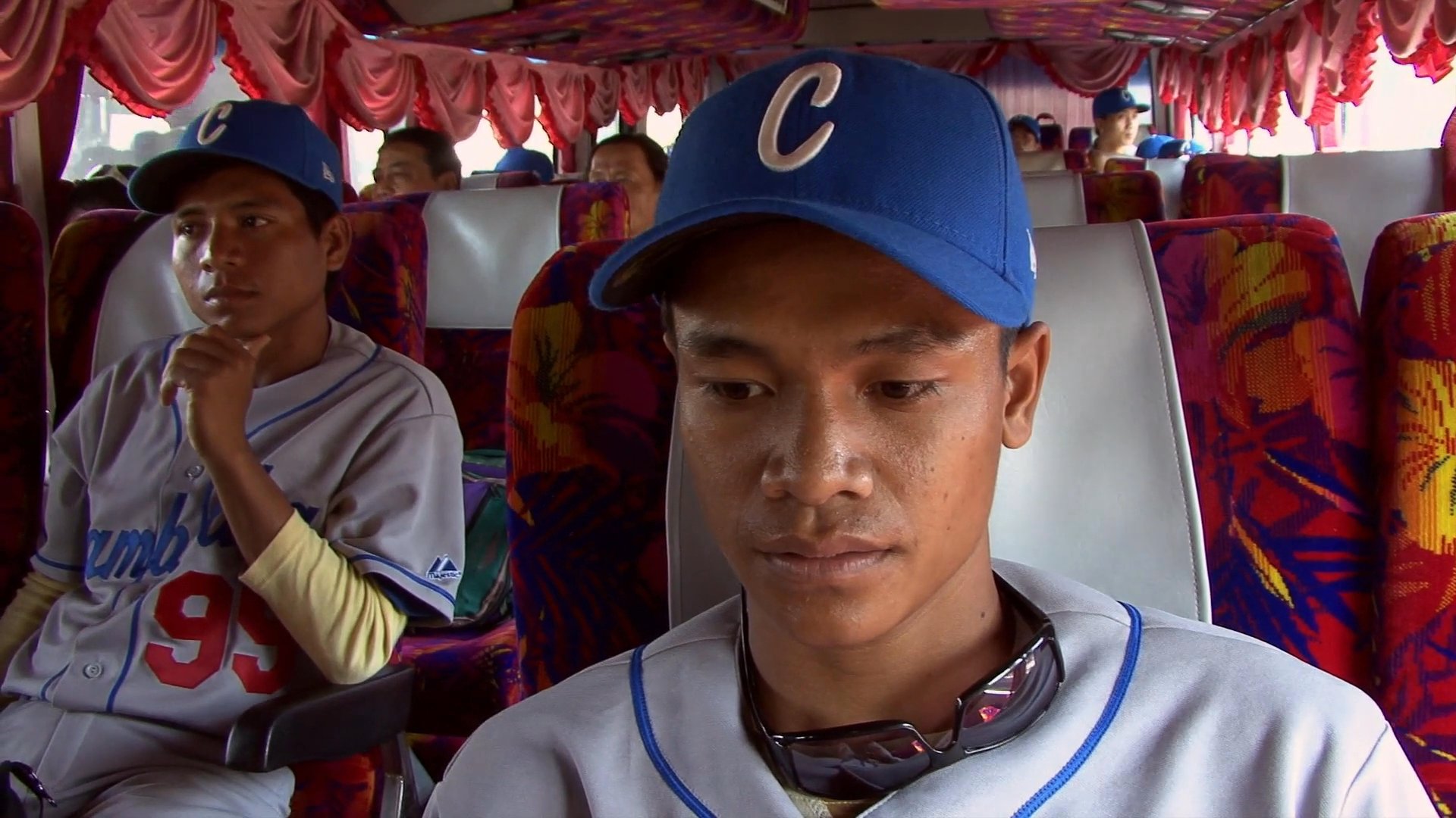 Baseball players in uniform share thoughts on their team's prospects and performance while traveling by bus. The athletes express cautious optimism and acknowledge their lack of experience as they prepare for upcoming challenges.