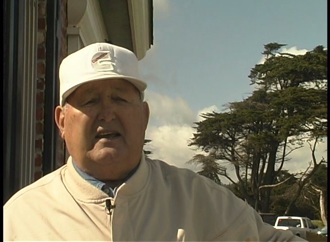 An older man in a white hat stands outdoors and addresses the camera, delivering a statement or providing testimony.