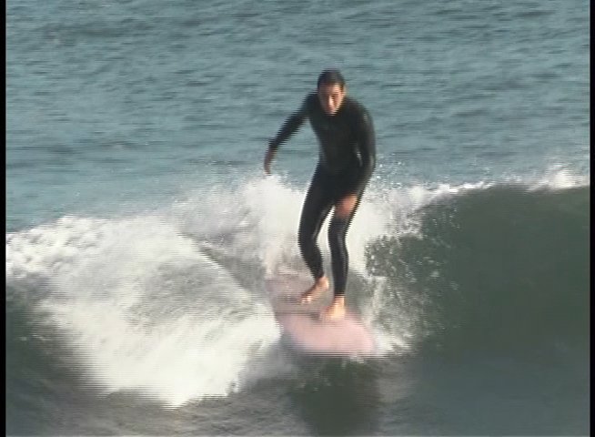 An instructor provides commentary while demonstrating high-level surfing techniques on ocean waves. The session juxtaposes professional analysis with action footage of a surfer navigating active swells.