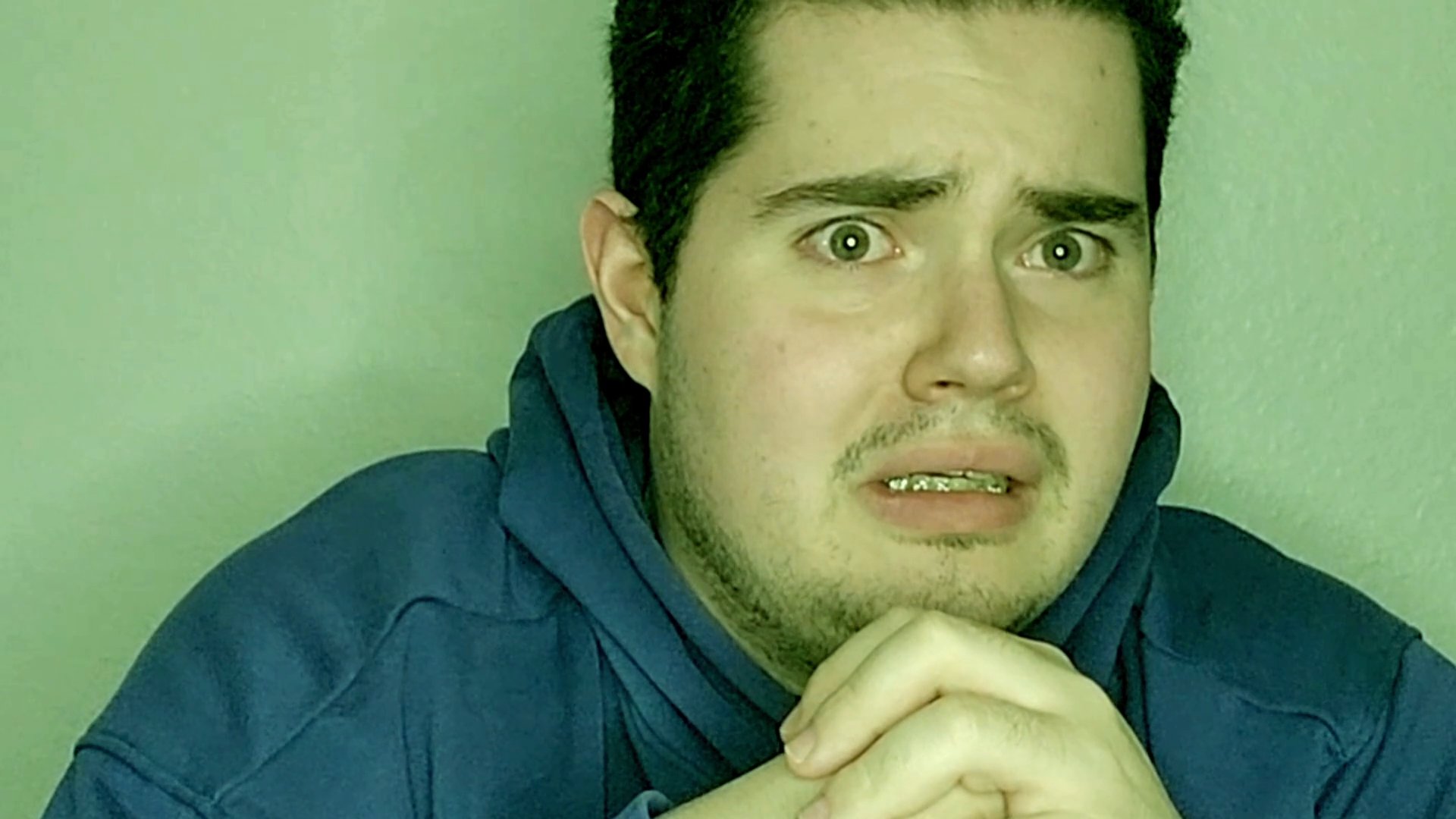 A man observes emotional content with a focused, concerned expression, occasionally interspersed with footage of an individual crying. The contrast highlights a sympathetic reaction to an impactful narrative.