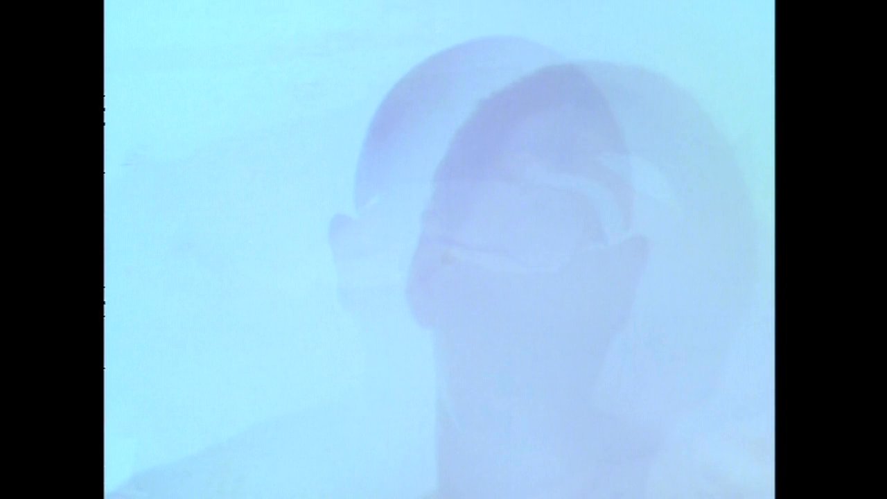 A man wakes from a slumber in a dimly lit bedroom, transitioning from a state of rest into a contemplative, hazy close-up.