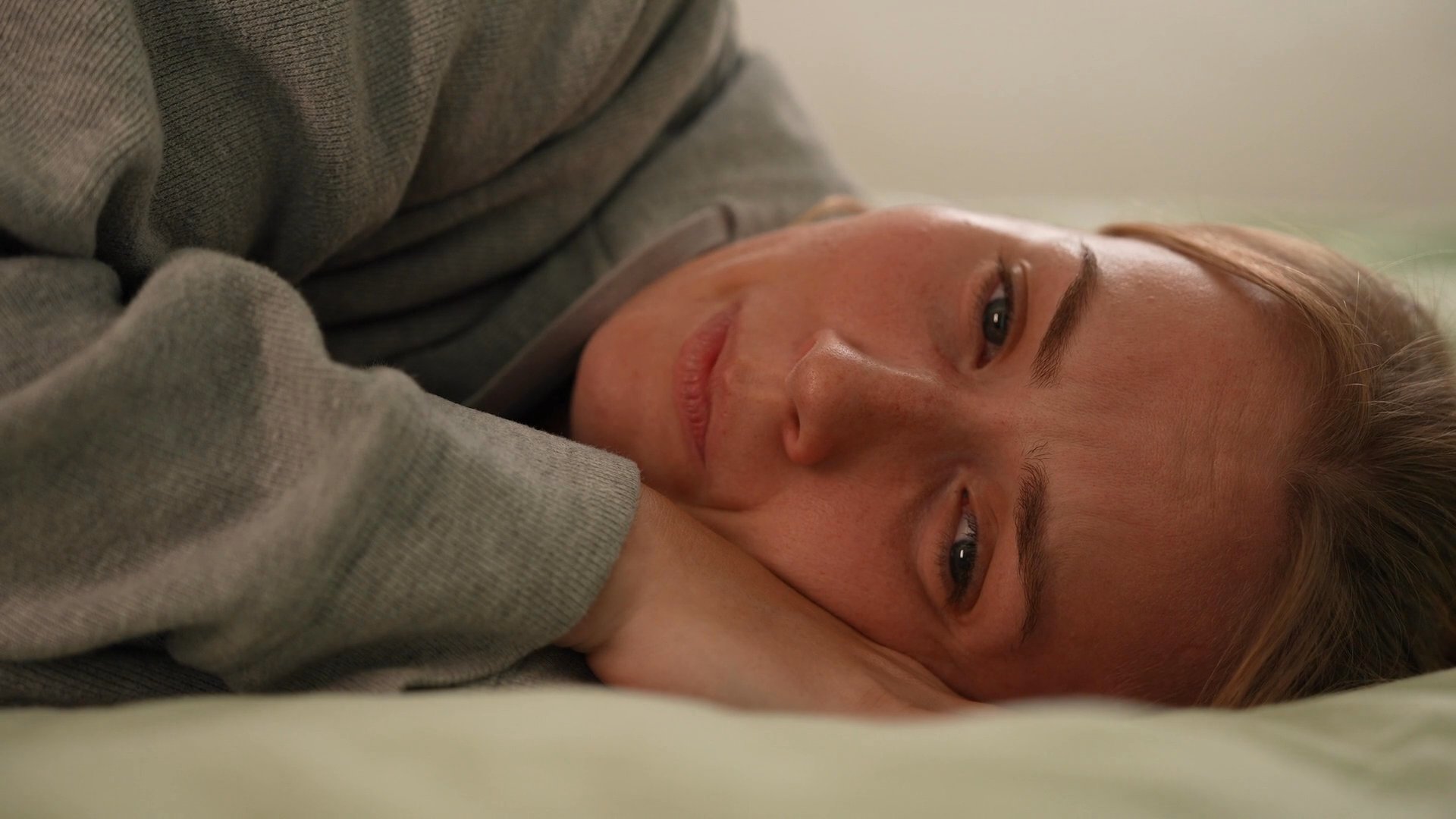 A man departs a room, leaving a woman alone in distress, contrasted against scenes of a social gathering. The narrative explores themes of emotional distance and disconnect within a relationship.