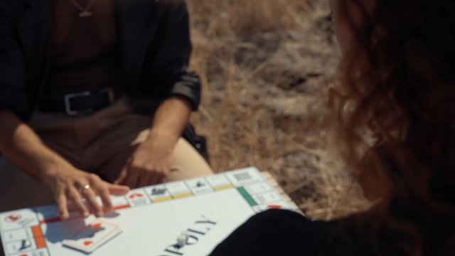 A girl draws a game card with the text "Have a kiss"