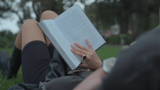 A girl reading a book in a park