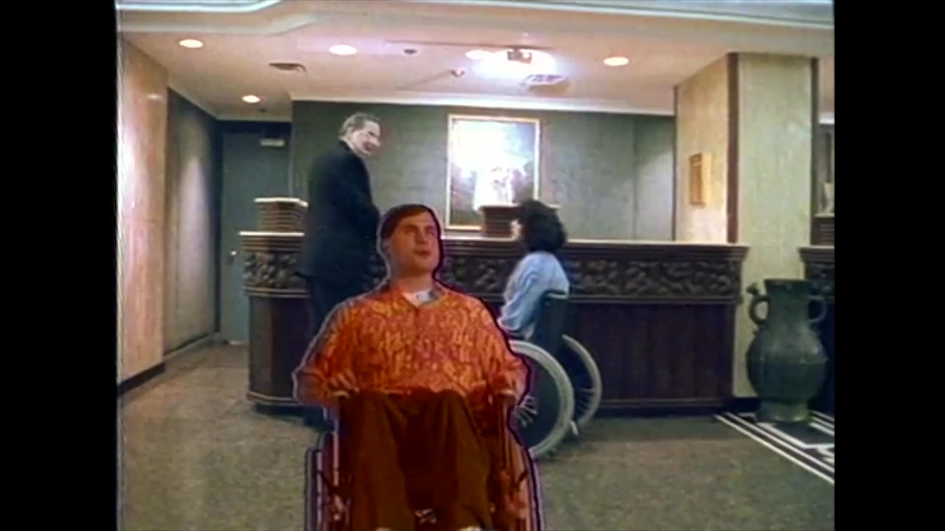 A man in a wheelchair navigates professional and service settings, transitioning from an indoor lobby to receiving automotive maintenance at a service station.