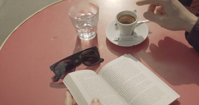Drinking coffee and reading a book in Paris
