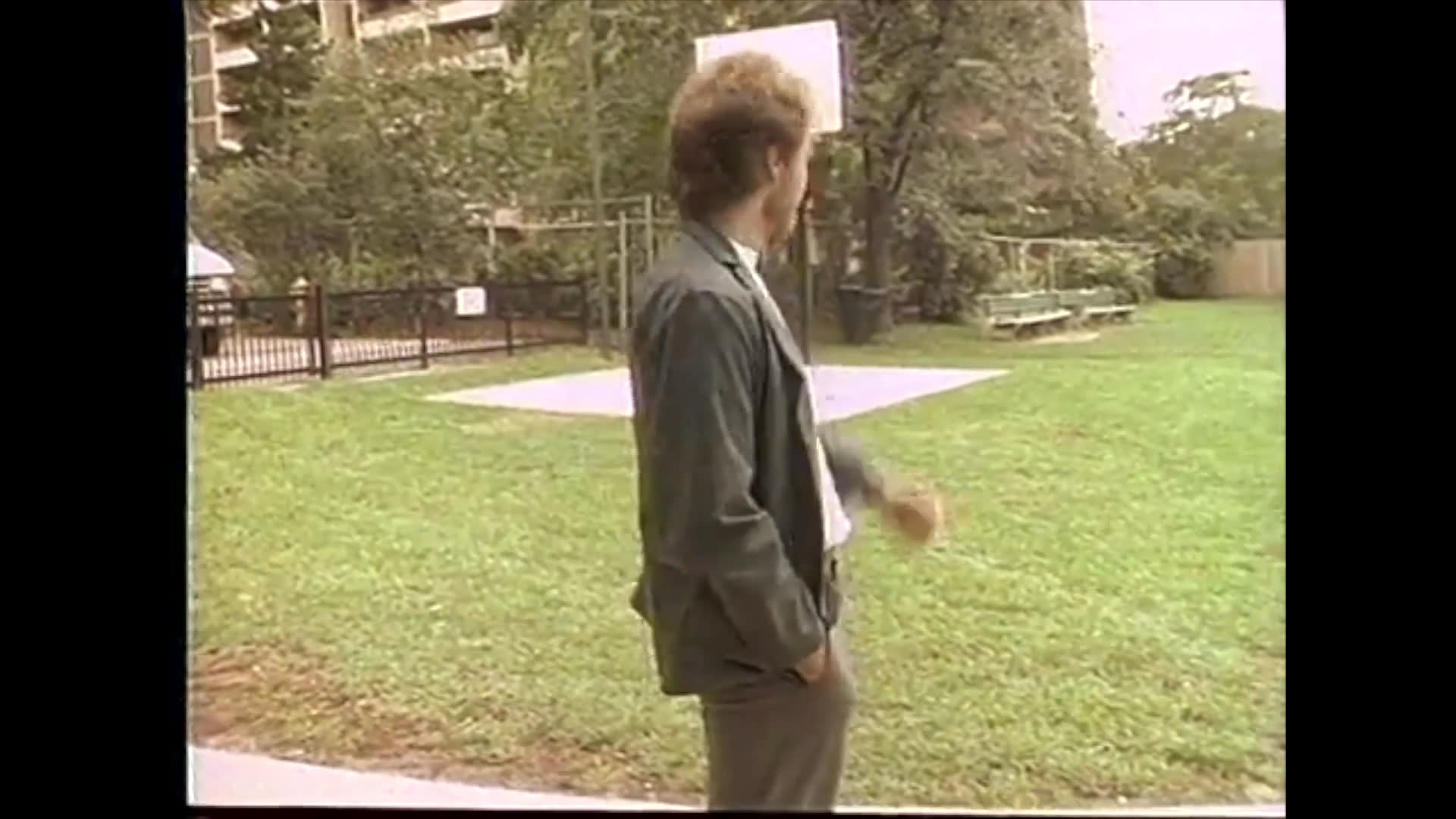 Two men communicate in an outdoor park setting, utilizing a specialized portable keyboard interface for assistance. The scene transitions to a detailed close-up of a blooming hibiscus flower.