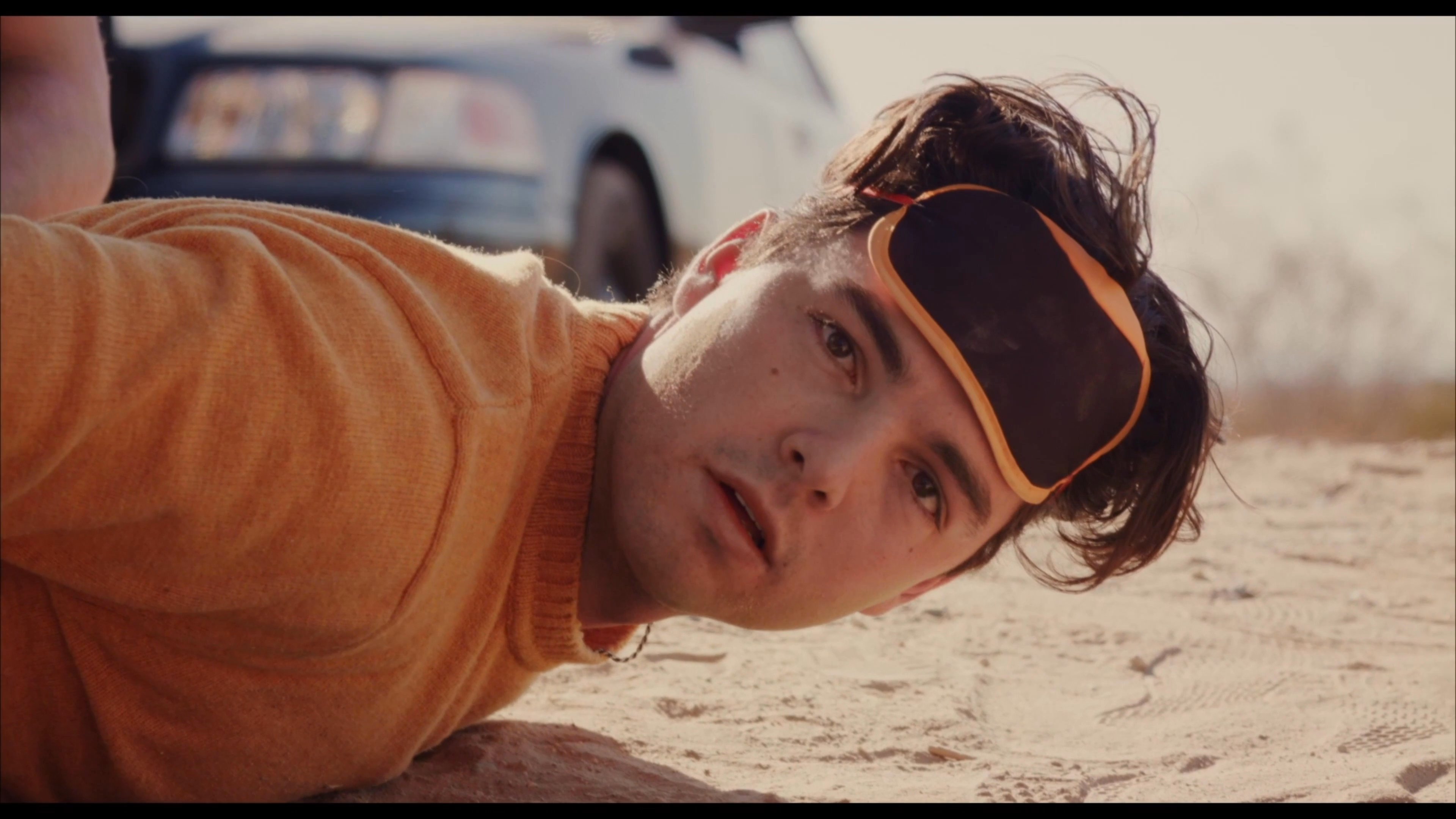 A German shepherd guards a desert scene where a person finds a hidden treat amidst tension. The individual uncovers a small capsule revealing a surprise contained within a chocolate egg.