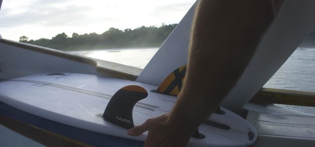 Man adjusting surfboard fins