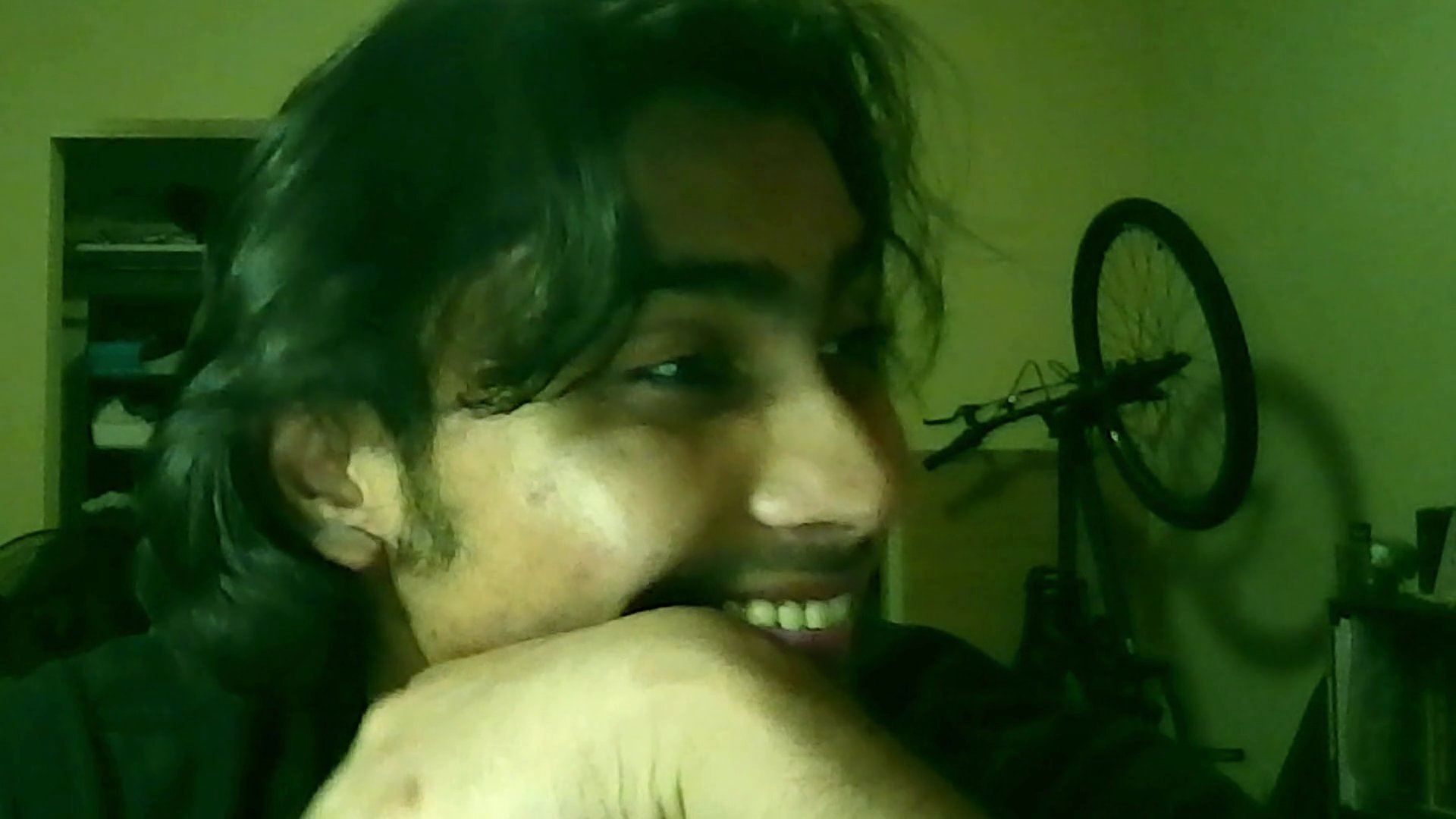 A man engages in a candid, expressive conversation, transitioning through various emotional states while speaking directly to the camera in an indoor setting.