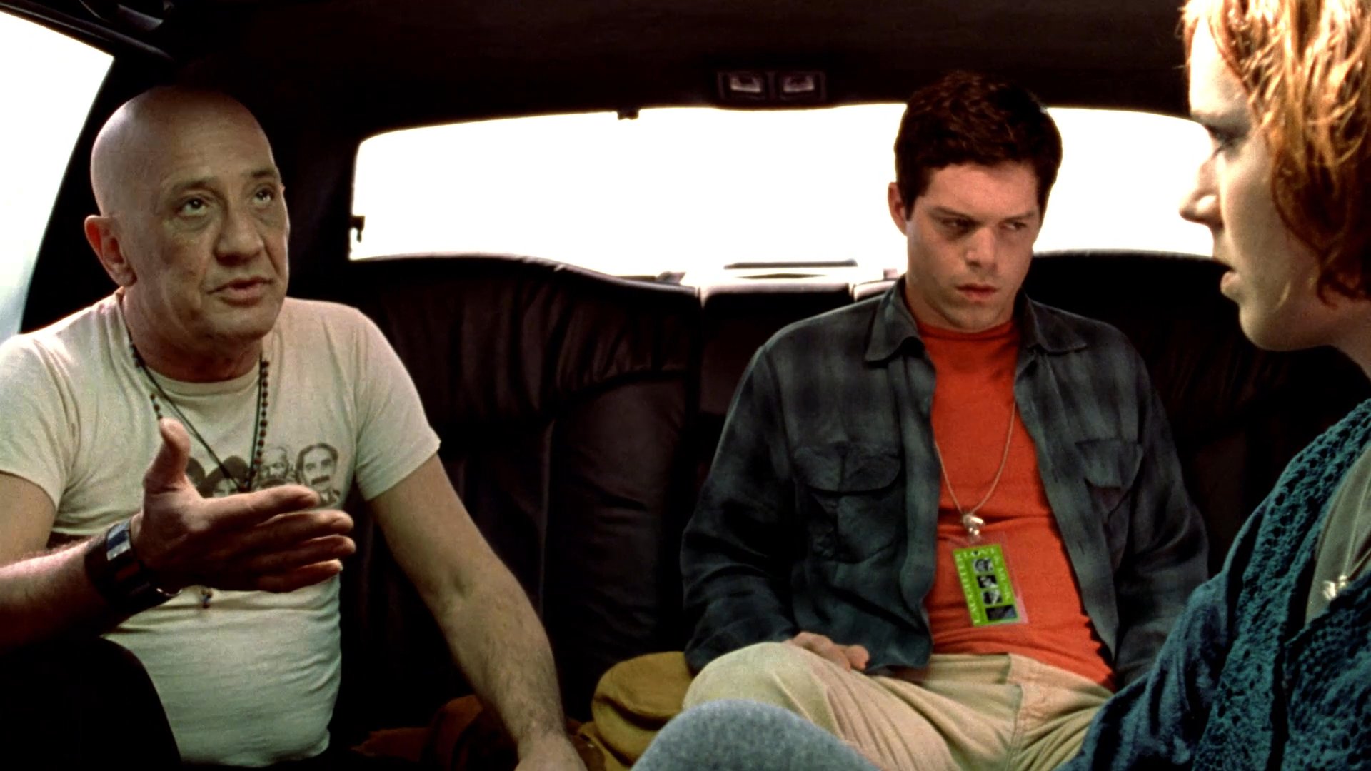 A group of individuals engages in an intense, animated conversation while riding together in the back of a moving limousine.
