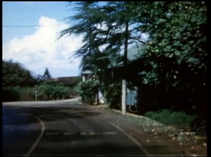 Footage of a scenic Hawaiian coastline and local street transition into an interview with an elderly man sharing memories. The sequence provides a visual bridge between the historic geography and personal narrative.