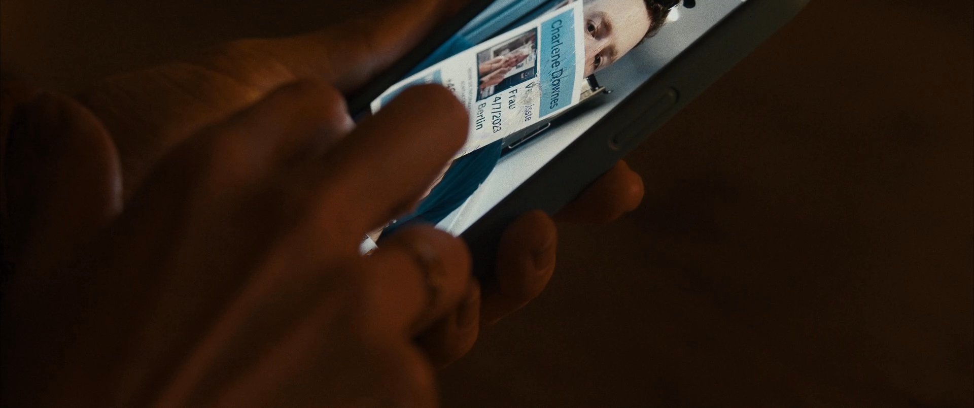An individual reviews various media on a smartphone, displaying a range of reactive facial expressions while navigating an image gallery.