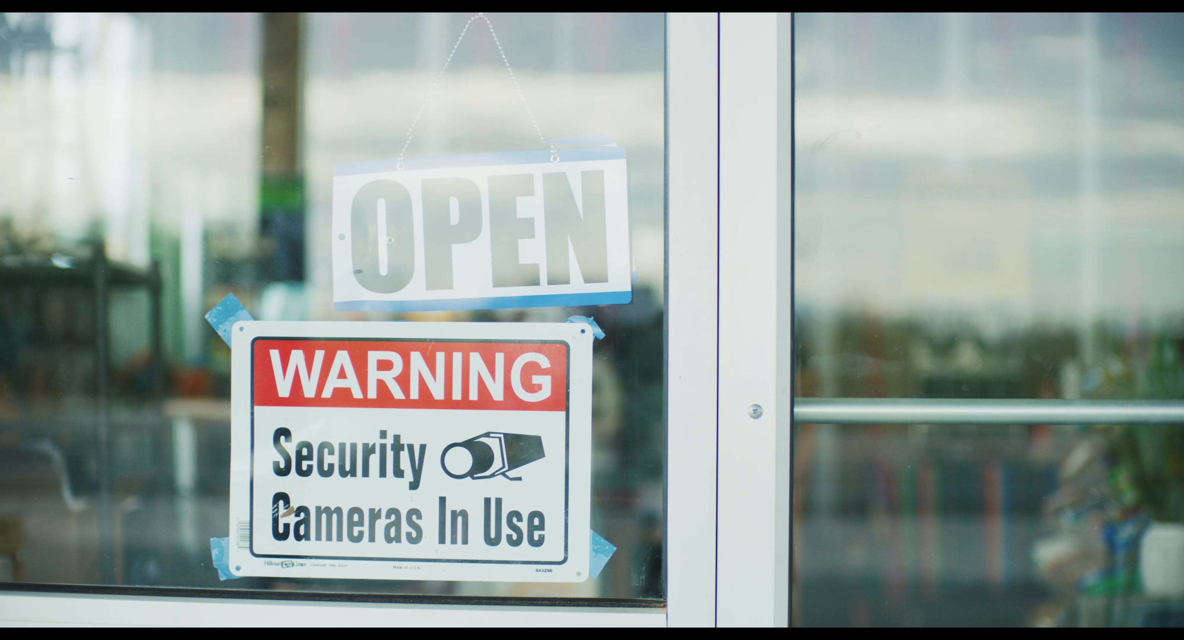 A store clerk organizes inventory within a retail establishment while external shots highlight the surrounding desert landscape and facility security measures.