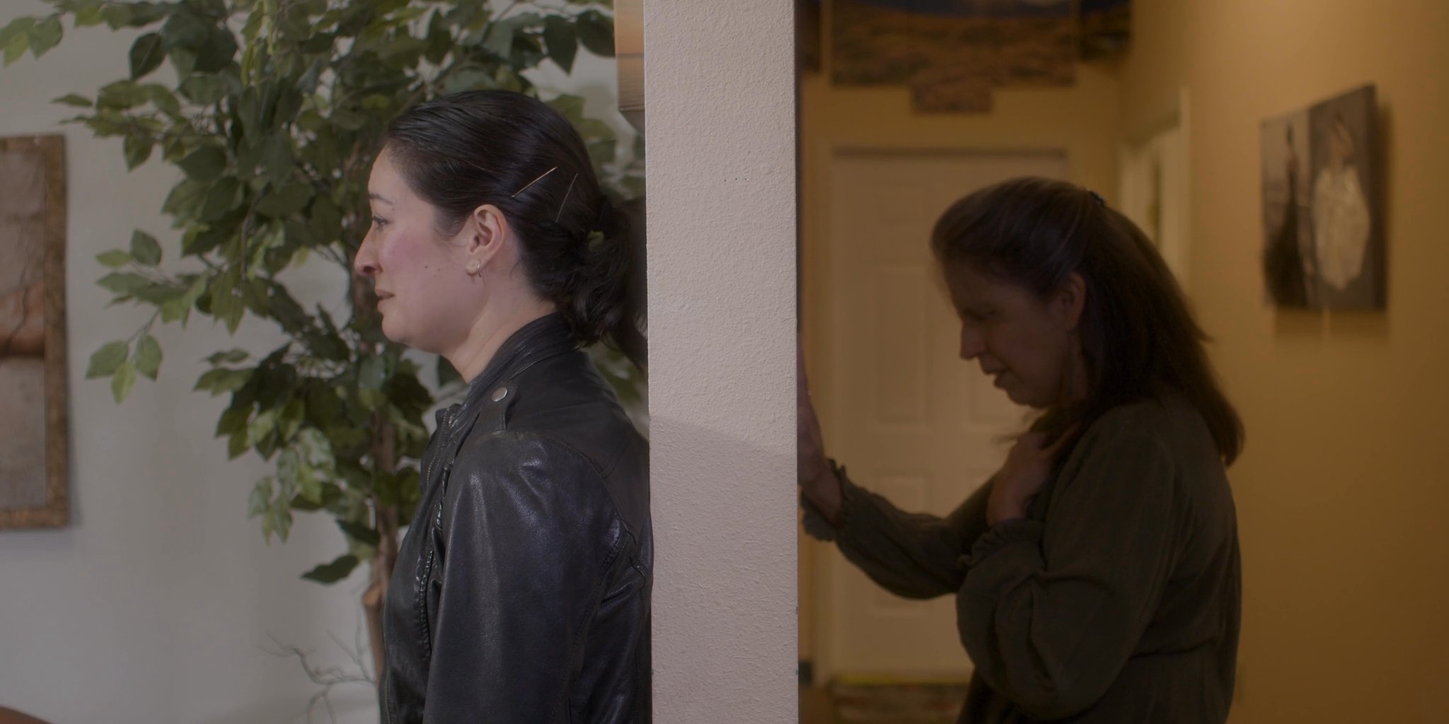 Two women engage in a poignant, emotional conversation, characterized by visible distress and supportive interaction within a home setting.