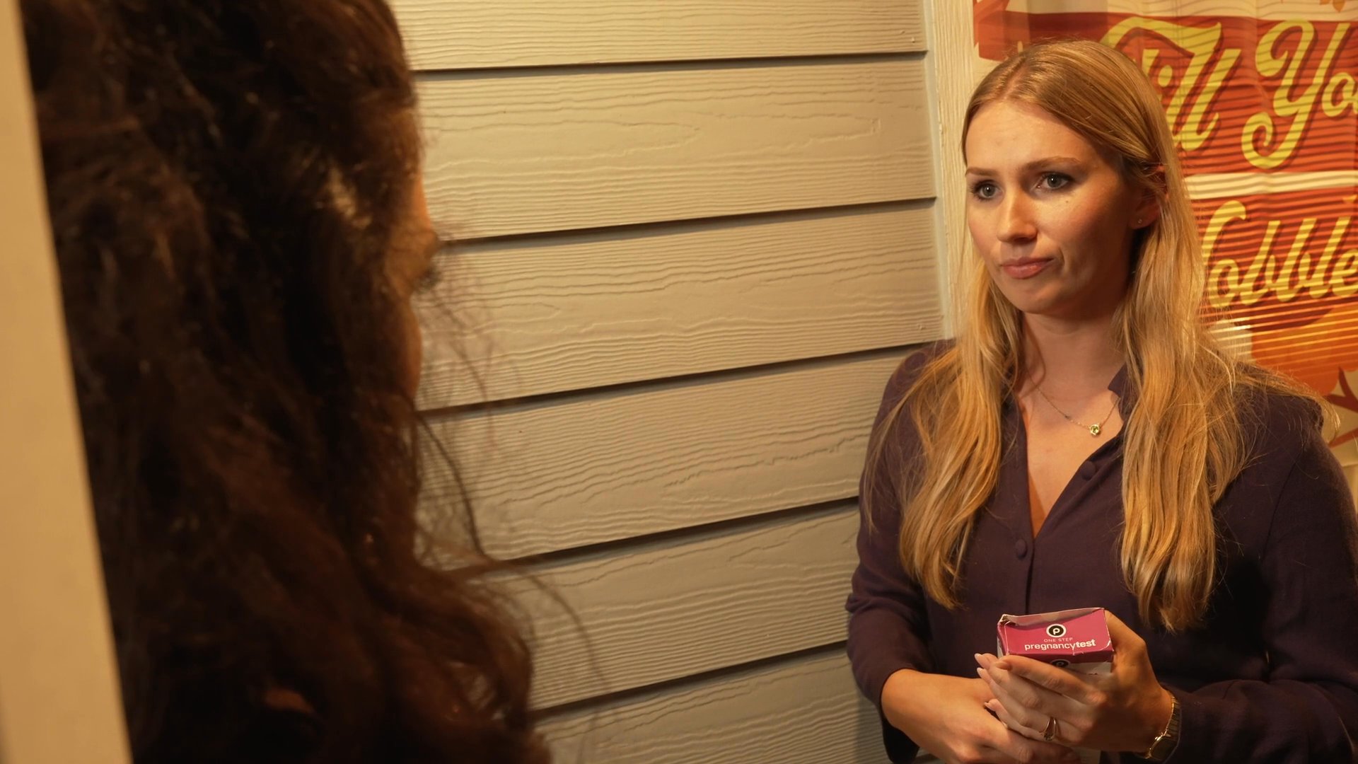A professional advisor presents and explains a skincare product to a client, facilitating a detailed product demonstration in a retail setting.