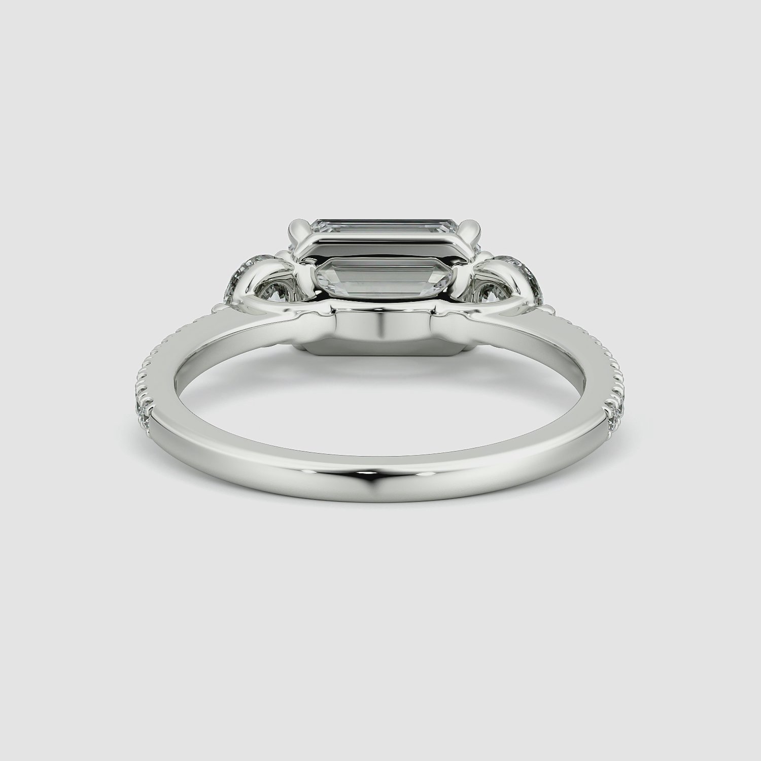 The Three Stone | Emerald | Platinum | bandAccent: Pavé | diamondOrientation: horizontal | sideStoneCarat: 0.25ct | sideStoneShape: Round Brilliant | caratWeight: other