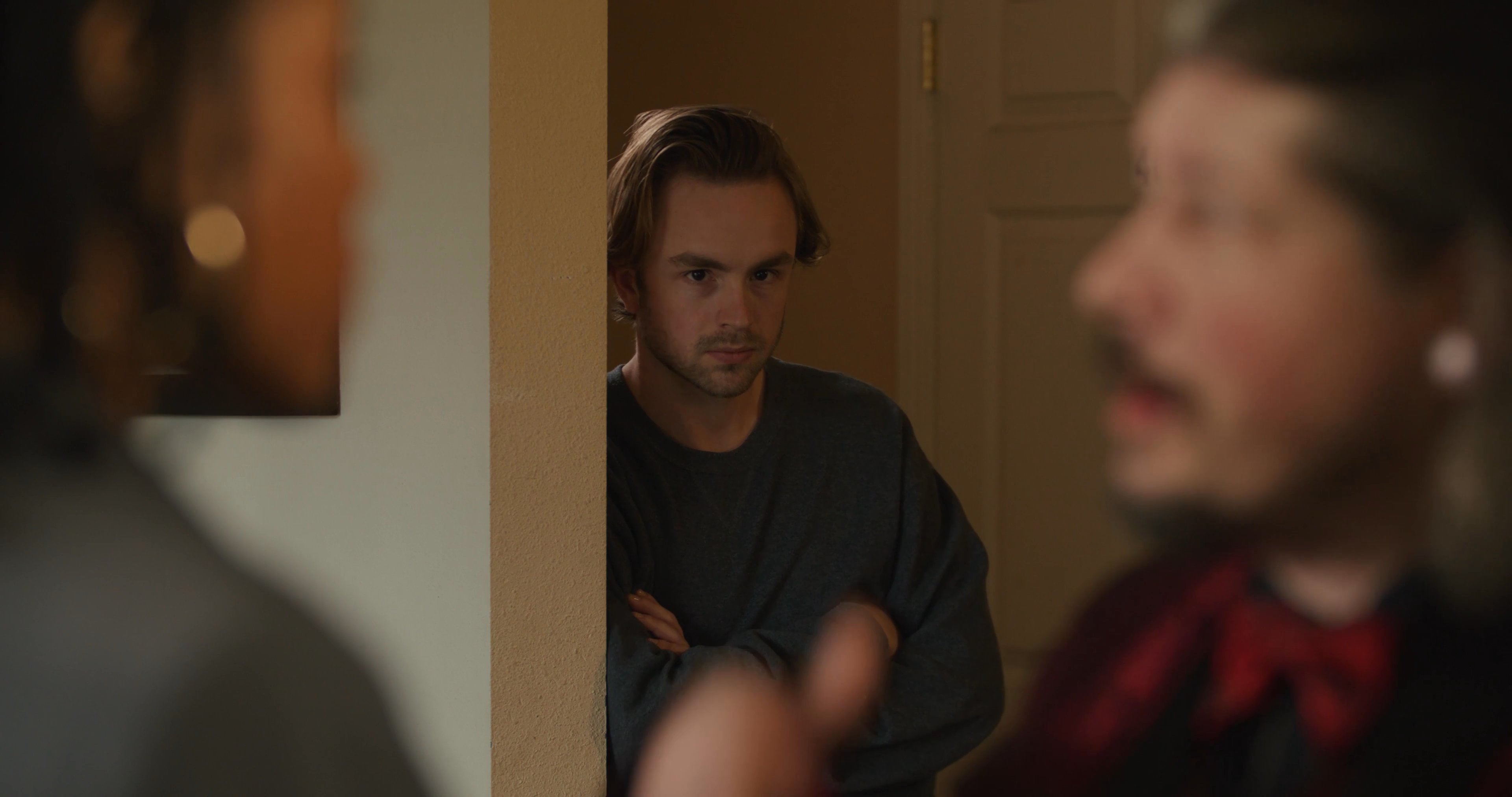 A man in a red formal jacket engages in an aggressive verbal confrontation with a female hotel employee. The interaction escalates in an office setting as the staff member attempts to manage the guest's behavior.