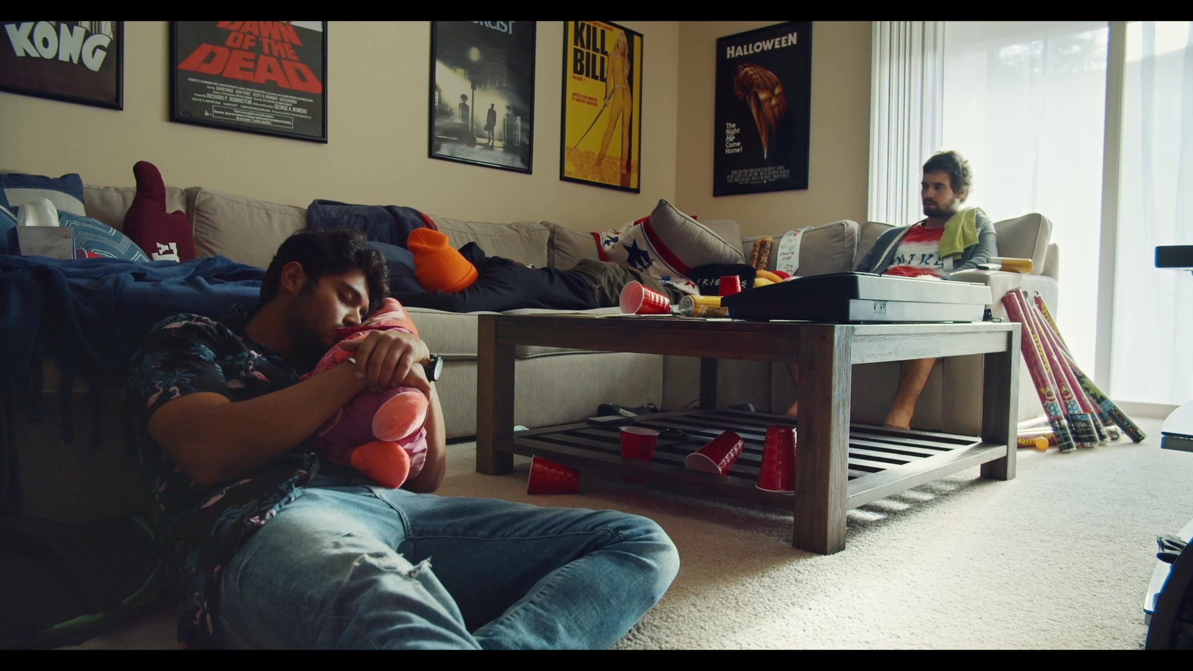 A man relaxes in a casual living room environment before transitioning to watching classic animated television programming.