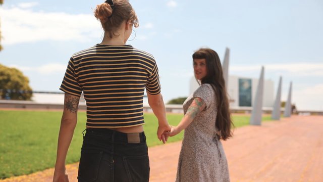Women holding hands outdoors