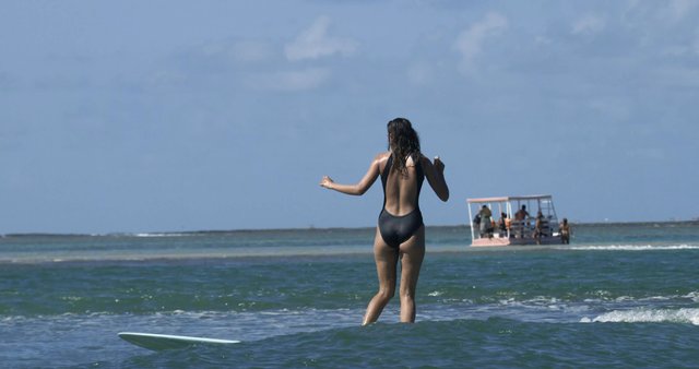 Una chica surfeando en el mar