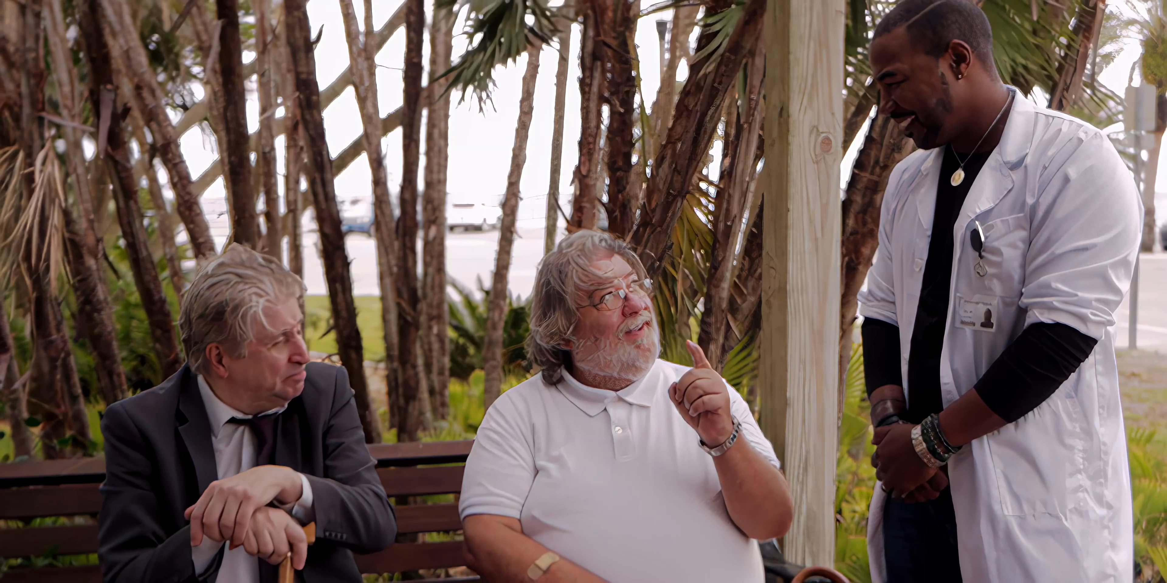 Three individuals engage in a professional discussion while seated on a bench in an outdoor setting. The interaction involves active communication and concludes with a formal handshake between the participants.