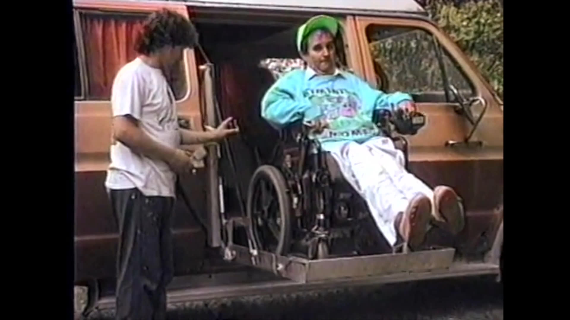 A man using a wheelchair navigates various environments, including an airport, a van with a lift, and a miniature golf course. The footage highlights assistive technology and the importance of accessible recreational spaces.