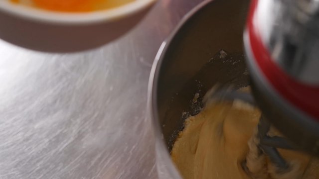 Pouring eggs into dough