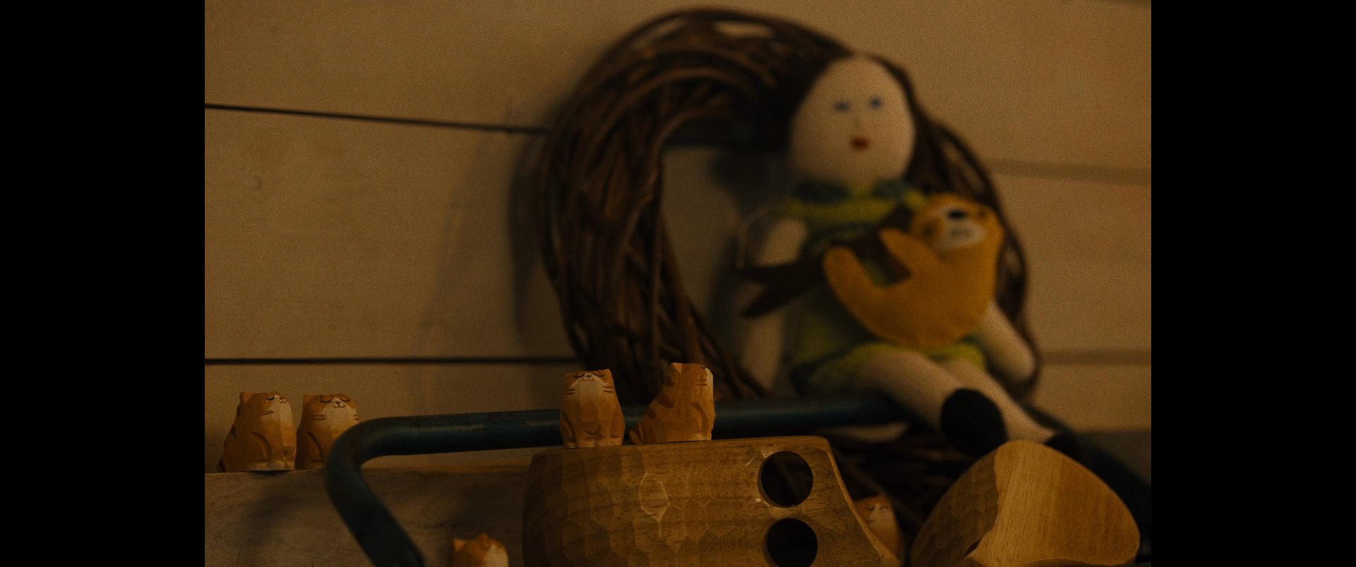 A decorative shelf displays various items including a doll and wooden figurine, transitioning to a blurred close-up of a smartphone screen featuring the text 'Never Hike Alone'.