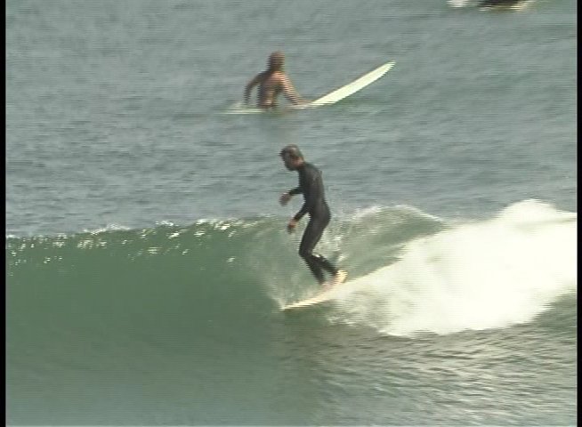 A man provides commentary while outdoor, followed by footage of a surfer navigating waves in a wetsuit.