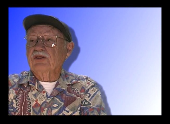 An elderly man recounts personal stories and historical experiences, accompanied by a visual overlay of a black-and-white photograph of a waterfront pier.