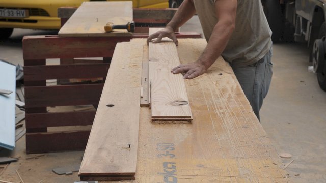 Carpenter cuts piece of wood