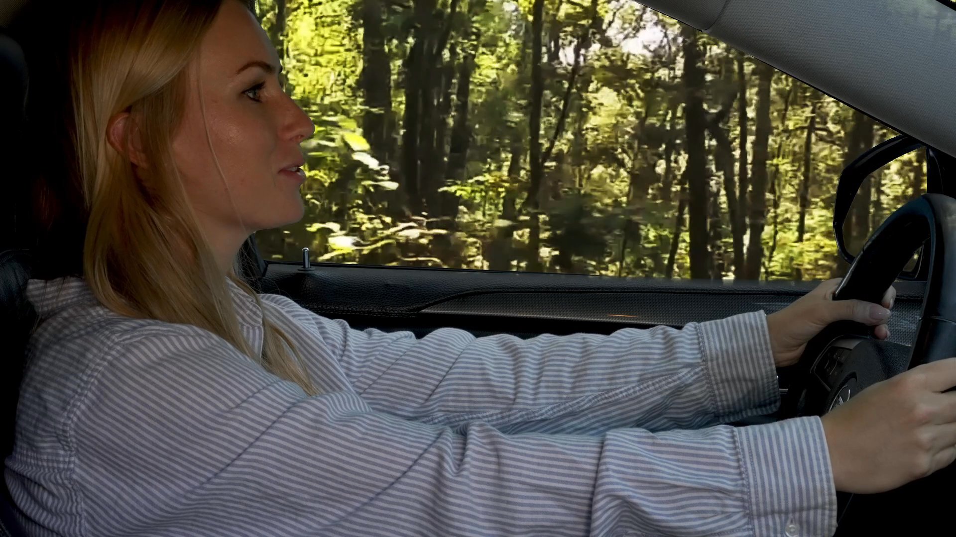 A woman and man depart from a house and begin driving through a scenic, tree-lined road while engaged in conversation.