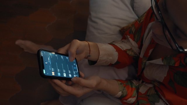 A girl browsing the online NFT marketplace using a smartphone app