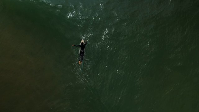 Man paddling over the waves