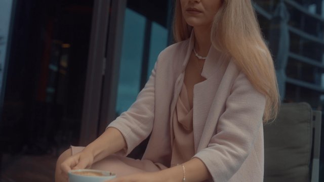 A woman smelling and tasting an aromatic coffee