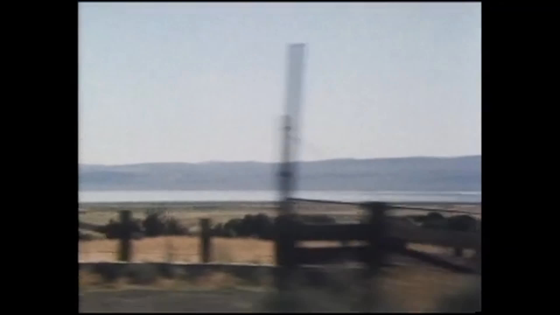 An older driver in a brimmed hat travels along quiet rural roads past a weathered barn and broad, dry countryside. Reflective narration celebrates an unhurried life, personal freedom, and enjoying what you do.