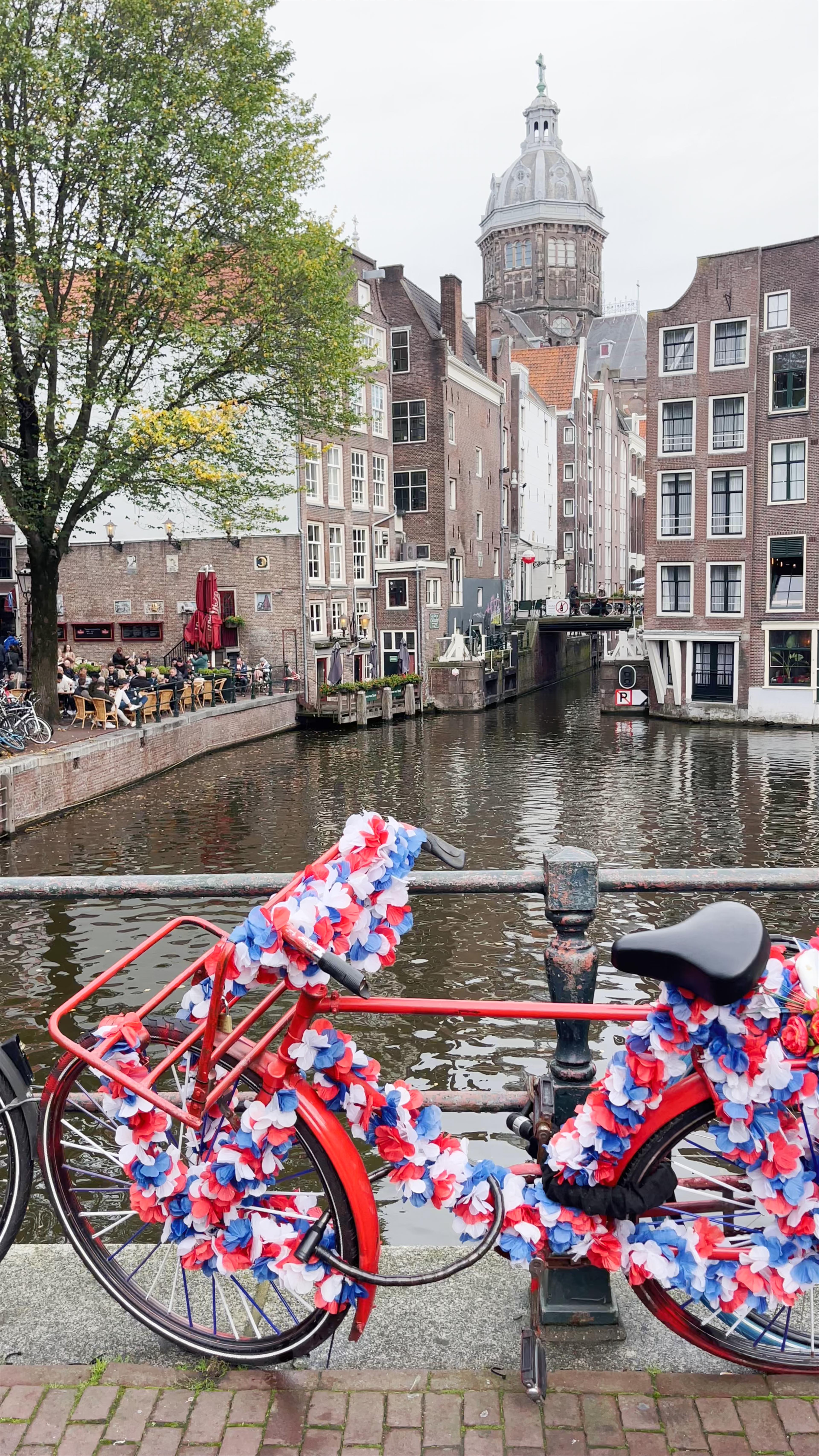 Iconic Amsterdam Canal Views with Vibrant Flower-Adorned Bicycle