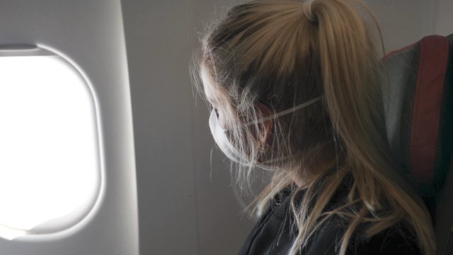 Woman looking out a plane window