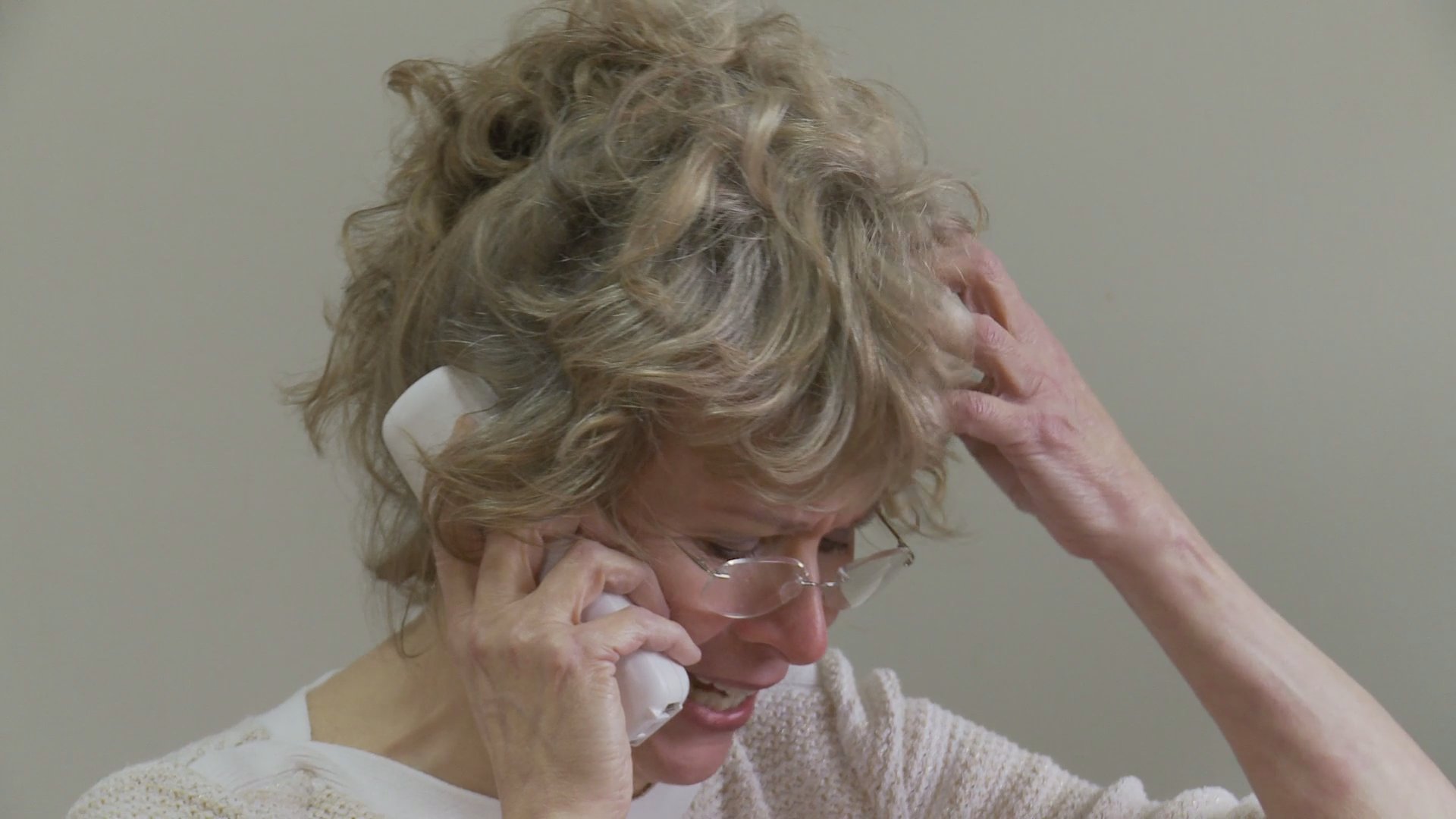 An older couple experiences significant emotional distress while communicating separately within their home. The sequence captures their palpable anxiety and sorrow during a difficult period.