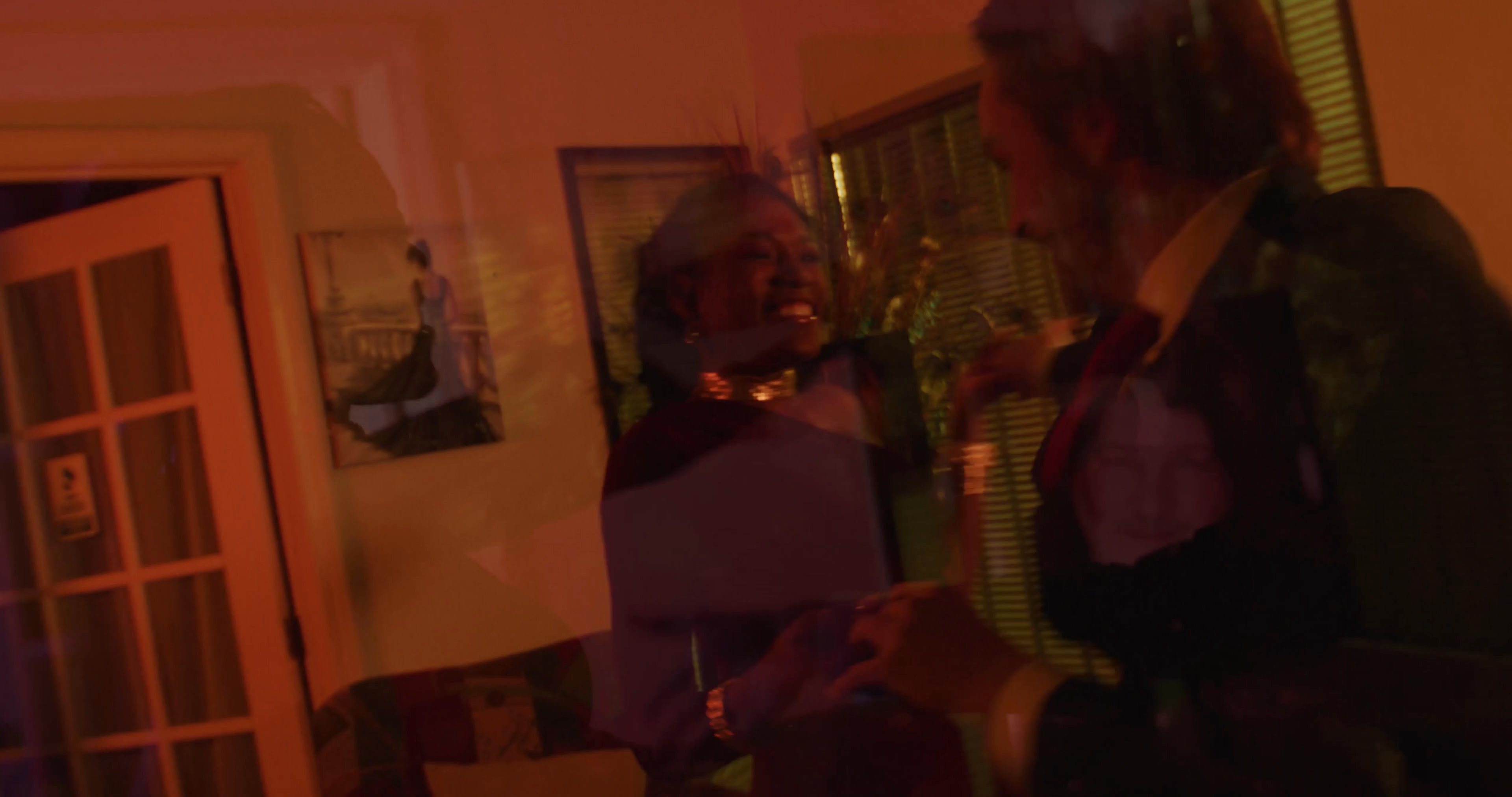 A man and a woman engage in a heated struggle inside a dimly lit room, followed by the man disposing of a trash bag and a pill bottle outdoors.