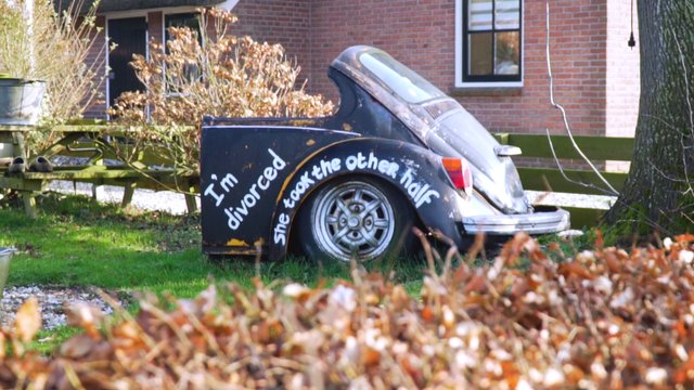 Destroyed car with funny, painted text