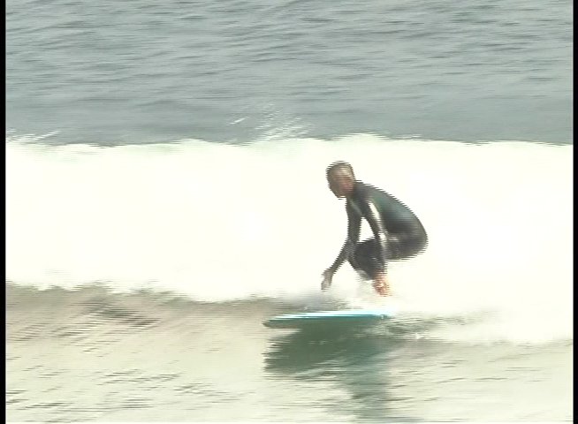 An experienced surfer demonstrates technical skill while riding multiple waves in the open ocean. The sequence showcases various maneuvers and balance transitions on a surfboard.