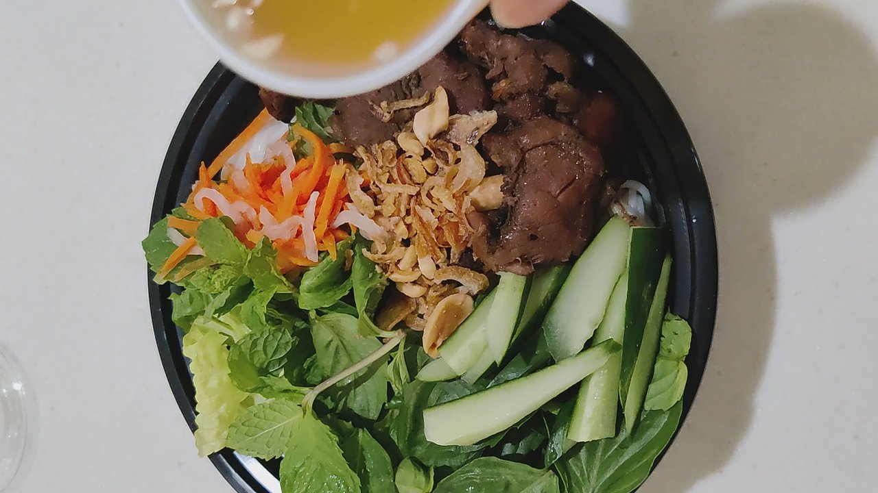 Bella Banh Mi Cafe - Pouring the sweet chili sauce onto the BBQ pork bowl - Sandwiches Near Me - Honolulu, Hawaii