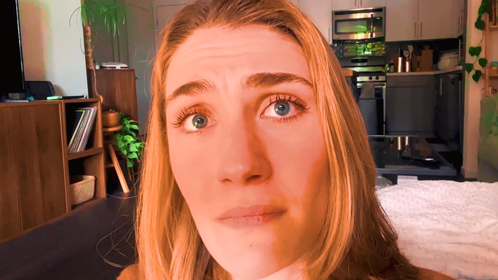 A woman speaks directly to the camera, using expressive facial gestures and varied vocal delivery to communicate a narrative or opinion from a home setting.