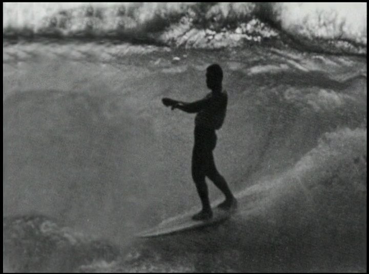 A skilled surfer maneuvers across powerful ocean waves, demonstrating balance and technique in a marine environment. The sequence highlights fluid movement and the dynamic interaction between the athlete and the surf.